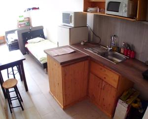 uma pequena cozinha com um lavatório e um micro-ondas em studios em Belfort