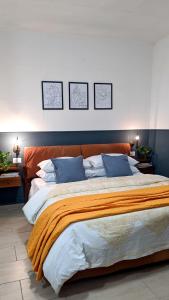 a bedroom with a large bed with an orange blanket at TOP Apartment in Catanzaro