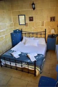 a bedroom with a bed with two towels on it at Ta' Salvu u Marija in Munxar
