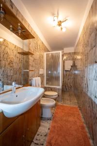 a bathroom with a sink and a toilet at Casa Viola Lodge in Isolaccia