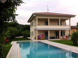 une villa avec une piscine en face d'une maison dans l'établissement Villa Paradiso del Garda Vista-Verde, à Bardolino