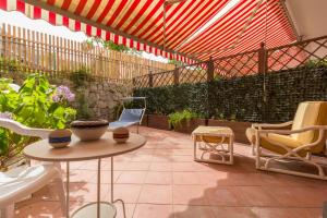 un patio con mesa, sillas y sombrilla en Maison Lillina, en Sorrento