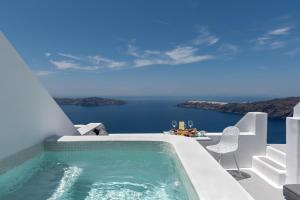 a large white tub sitting next to a body of water at Kasimatis by La Perla - Adults Only in Imerovigli