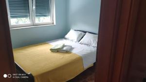 a bed with two towels sitting on top of it at Gloria Apartments in Herceg-Novi