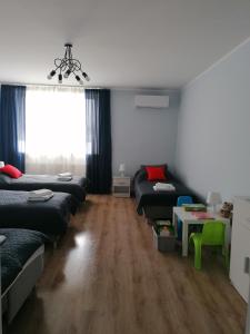 a room with four beds and a table and a window at Gladiator Noclegi Zator lV Apartament in Zator