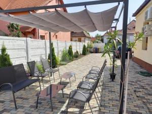 a patio with chairs and a white umbrella at Casa Geppetto in Sibiu