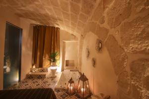 Habitación con pared de piedra y mesa con luces. en Suite Terracielo, en Monopoli