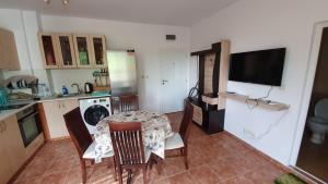 a kitchen with a table and chairs and a television at Pomorie Beach Resort in Pomorie