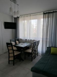 a dining room with a table and chairs and a bed at Gladiator Noclegi Zator lV Apartament in Zator