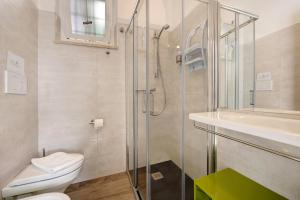 a bathroom with a shower and a toilet and a sink at Residence La Mignon Terrazza in Torri del Benaco +22 photos
