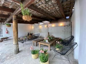 un patio con mesas, sillas y flores en un edificio en Posada Colibri - Hotel & Spa, en San Juan Teotihuacán