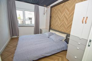 um quarto com uma cama e uma grande janela em Casa Monkey Pärnu with sauna and terrace em Pärnu