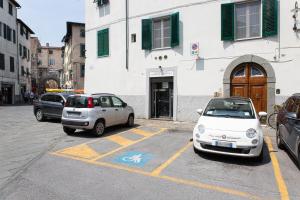 dwa samochody zaparkowane na parkingu przed budynkiem w obiekcie Casa delle Stelle Luxury w Lukce