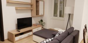 ein Wohnzimmer mit einem Sofa und einem Flachbild-TV in der Unterkunft Tincha in Piran