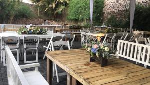 un groupe de tables et de chaises avec des fleurs sur elles dans l'établissement Posada Colibri - Hotel & Spa, à San Juan Teotihuacán