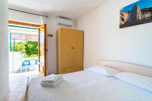 1 dormitorio con cama blanca y puerta corredera de cristal en Casa Colletta Vieste en Vieste