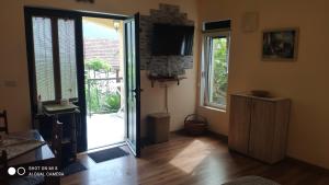 a living room with a sliding door and a television at Gloria Apartments in Herceg-Novi
