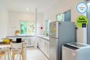 a kitchen with a refrigerator and a table with chairs at Ao Luek Panoramic Pool-SHA Plus in Ao Luk