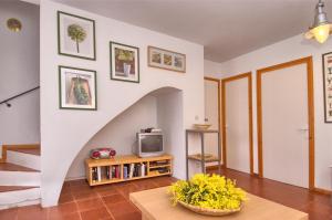 ein Wohnzimmer mit Fernseher und Tisch in der Unterkunft Sa Tuna "Casas CE MA" in Begur