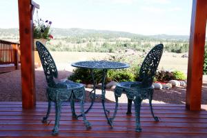 two chairs and a table on a porch at Sawin' Logs Inn in Devils Tower