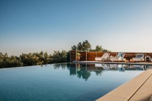 una piscina con due sedie a sdraio e una piscina di Villa Elithea a Éxo Khóra