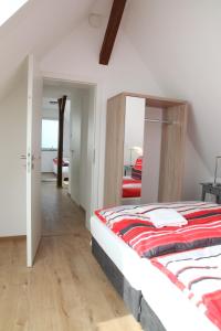 a bedroom with a bed with a red blanket on it at Schwaben Apartment Plus in Oberboihingen