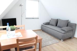 un soggiorno con divano e tavolo di Schwaben Apartment Plus a Oberboihingen