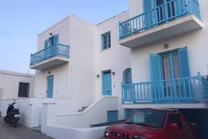 a red car parked in front of a white building at Traditional Concept Apartments Placidity in Aliki