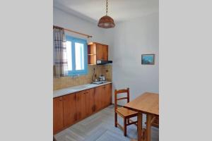 a kitchen with a wooden table and a dining room at Traditional Concept Apartments Placidity in Aliki