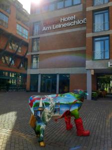 una statua di una mucca di fronte a un edificio di Concorde Hotel am Leineschloss ad Hannover