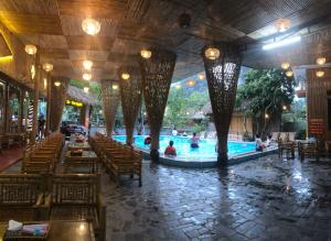 een zwembad in een restaurant met tafels en stoelen bij Trang An River View Homestay in Ninh Binh