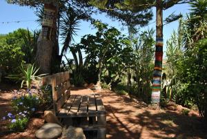 a bench sitting in the middle of a garden with trees at Vivenda Familia Pedro in Vila do Bispo
