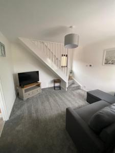 uma sala de estar com um sofá e uma televisão em Newly Refurbished Beautiful Location 1 Bedroom Residential House sleeps 4 em Cramlington