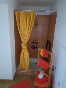 a shower with a yellow shower curtain and a tub at Ferienwohnung Villa Frosch in Meiningen