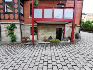 a brick building with a red roof and a courtyard at Ferienwohnung Villa Frosch in Meiningen