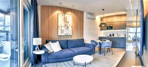 ワルシャワにあるMennica Residence Iの青いソファとキッチンのあるリビングルーム