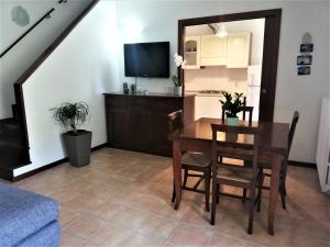 a living room with a dining room table and a television at Amore Cove Apartment - Riomaggiore - 5 terre in Riomaggiore