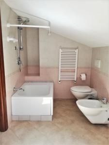 a bathroom with a white tub and a toilet at Amore Cove Apartment - Riomaggiore - 5 terre in Riomaggiore