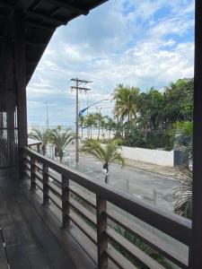 a porch with a view of the beach and palm trees at Charme Hotel Guarujá Frente Mar in Guarujá