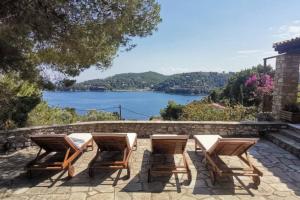 a group of chairs and tables with a view of a lake at Luxury Villa in Sklithri in Skiathos Town