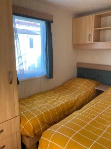 Habitación pequeña con 2 camas y ventana en Classic bungalow by the IJsselmeer, en Workum
