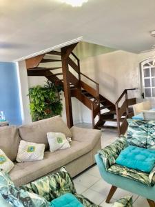 a living room with a couch and a staircase at Linda casa frente mar pé na areia praia Flamengo in Salvador