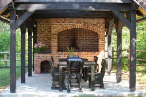 a brick patio with a table and a fireplace at Timber valley in Plitvička Jezera