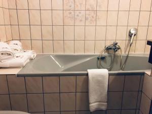 a bathroom with a tub with a shower and towels at Chaume de Balveurche in Xonrupt-Longemer