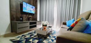a living room with a couch and a tv at Luxuria Apartamento Palazzo di Italia in Goiânia