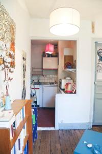 uma cozinha com armários brancos e uma grande luminária em Charming Bright Apartment Near Montmartre em Paris