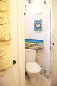 bagno con servizi igienici e un dipinto sul muro di Charming Bright Apartment Near Montmartre a Parigi