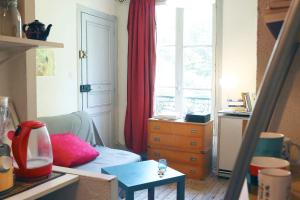 un soggiorno con cassettiera e finestra di Charming Bright Apartment Near Montmartre a Parigi