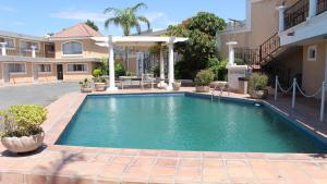 a swimming pool in front of a house at Hotel La Villa in Torreón +10 photos