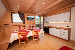 a kitchen with a table and chairs in a room at Casa Viola Lodge in Valdidentro